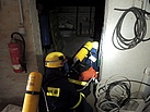 Atemschutzgeräteträger mit Handlampen und erschwerten Bedingungen im Keller